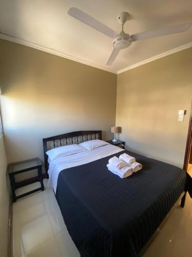 1 dormitorio con 1 cama grande y ventilador de techo en Departamento Alsina al mil en Salta