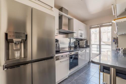 une grande cuisine avec des appareils en acier inoxydable et un comptoir dans l'établissement Veeve - Village Vision, à Paris