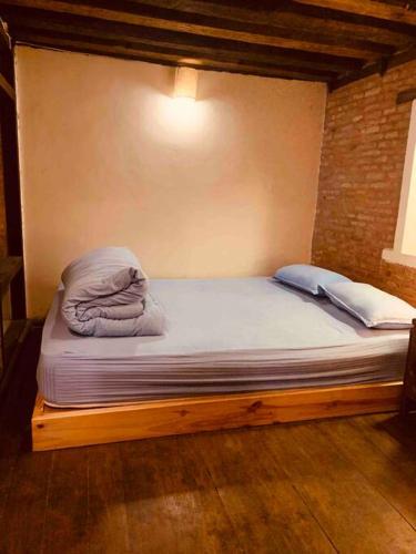 a bed sitting in a room with at Traditional Nepali Style 1 & 2 BHK Apartments, Humble Home, Patan in Pātan