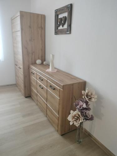 a dresser in a room with a vase with flowers at Villa Garden in Bešeňová
