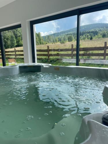 a jacuzzi tub with a view of a field at Helenowa Polana in Stary Gieraltow