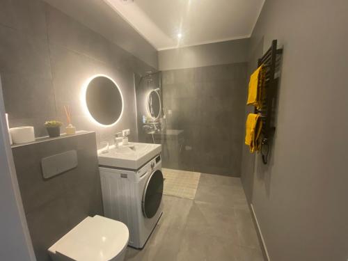 uma casa de banho com uma máquina de lavar roupa e um WC em Albatross_resort_alejaa em Ķesterciems