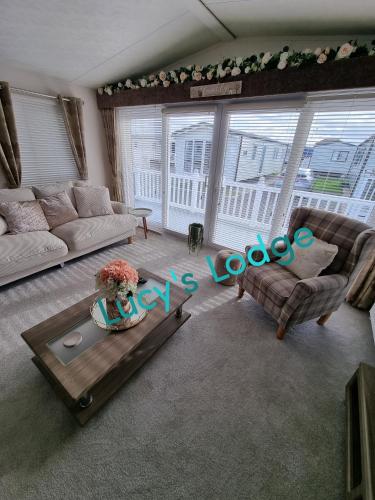 a living room with a couch and a table at Lucy's Lodge in Rhyl