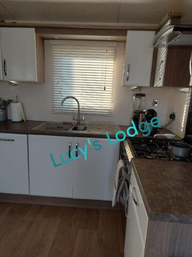 a kitchen with a sink and a stove top oven at Lucy's Lodge in Rhyl