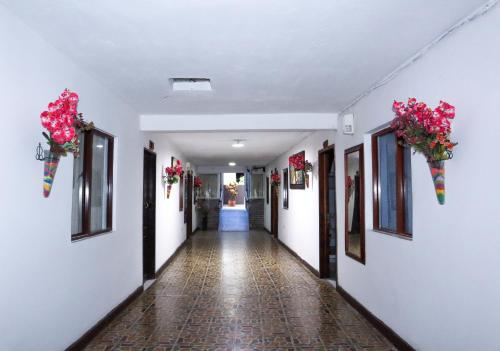 an empty hallway with flowers on the walls and flowers on the wall at Hotel Los Almendros in Santa María