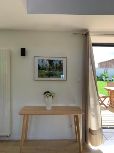 a wooden table in a room with a window at Les écuries du Nevez in Plonéour-Lanvern