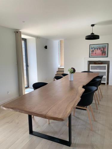 a dining room with a wooden table and chairs at Les écuries du Nevez in Plonéour-Lanvern