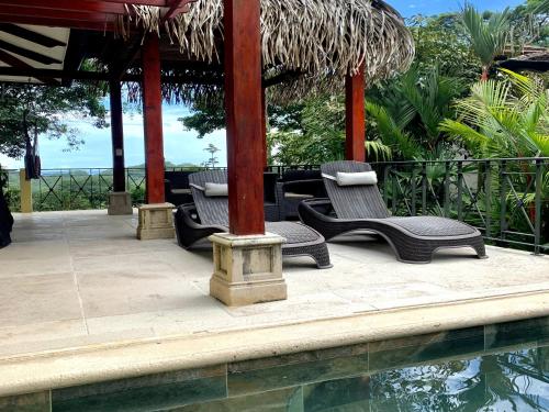 a group of chairs sitting next to a swimming pool at Villas by Tekoa in Uvita