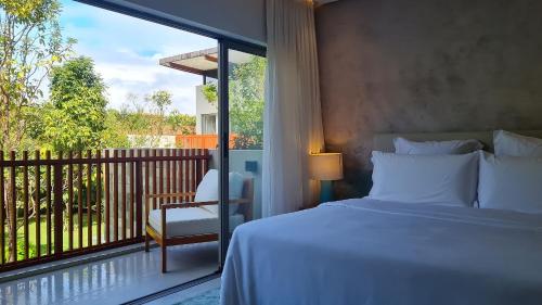 - une chambre avec un lit et un balcon avec une fenêtre dans l'établissement Qavi - Suíte luxuosa na rua principal #ÎledePipa, à Pipa