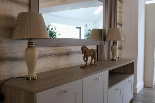 two lamps on a dresser in a room with a mirror at Northumberland Luxury Stays - The Newland in West Chevington