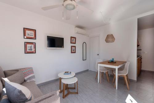 a living room with a couch and a table at Apartamentos Las Brisas I & II in Cala'n Bosch