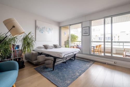 ein Schlafzimmer mit einem Bett und ein Wohnzimmer mit einem Sofa in der Unterkunft Veeve - Scenes of the Eiffel Tower in Paris
