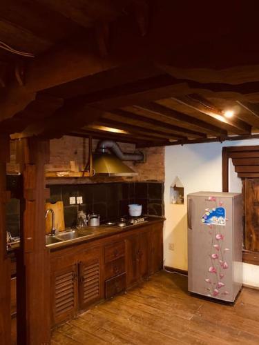 a kitchen with a stainless steel refrigerator and wooden cabinets at Traditional Nepali Style 2 BHK Apartments, Humble Home, Patan in Pātan