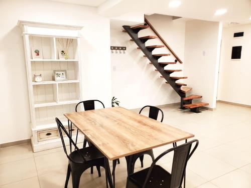 里奧格蘭德的住宿－House Rental RG_Departamento#1，一间带木桌和楼梯的用餐室