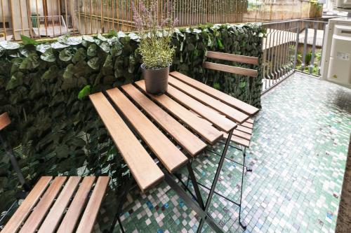 un banc en bois avec une plante en pot sur une terrasse dans l'établissement PrimoPiano - K51, à Milan