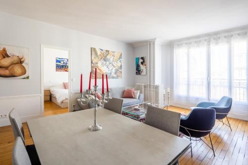 une salle à manger blanche avec une table et des chaises dans l'établissement Veeve - Dreaming in the Daytime, à Paris
