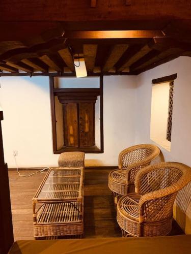a room with wicker chairs and a table and a window at Traditional Nepali Style 2 BHK Apartments, Humble Home, Patan in Pātan