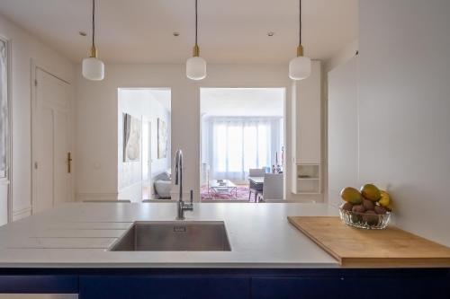 - une cuisine avec un évier et un bol de fruits sur un comptoir dans l'établissement Veeve - Dreaming in the Daytime, à Paris