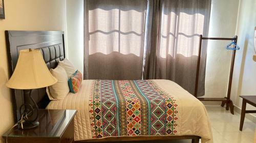 a bedroom with a bed with a table and a lamp at Mansion Serrano Hotel in El Fuerte