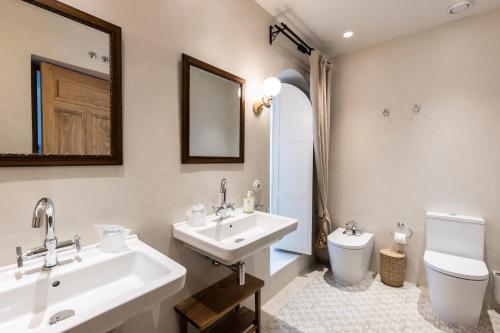 y baño con lavabo, aseo y espejo. en Casa Pizarro Hotel, en Cáceres