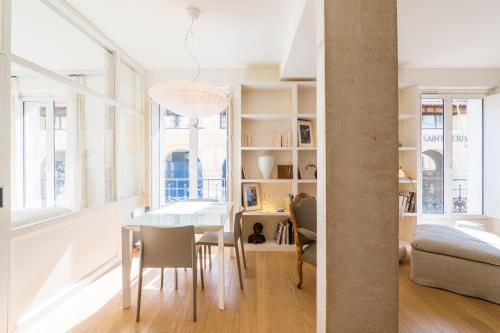 a dining room and living room with a table and chairs at Veeve - Alabaster Bright in Paris