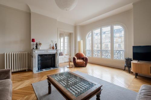 ein Wohnzimmer mit einem Kamin und einem TV in der Unterkunft Veeve - A Window to Paris in Paris