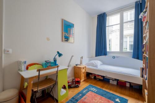 ein kleines Schlafzimmer mit einem Bett und einem Fenster in der Unterkunft Veeve - A Window to Paris in Paris
