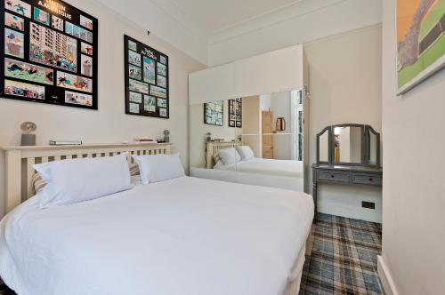 a bedroom with a white bed and a bathroom at Veeve - The Southern Scenester in London