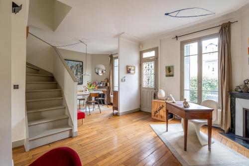 un salon avec un escalier et une table dans l'établissement Veeve - Enchanted Hideaway, à Boulogne-Billancourt