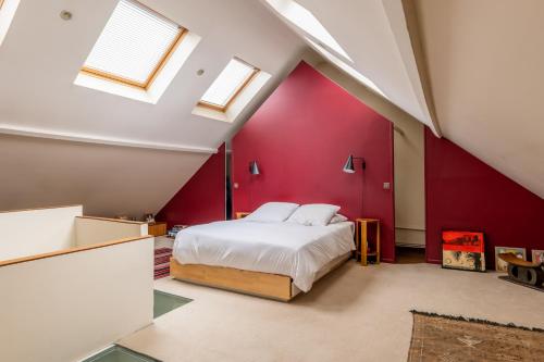 - une chambre avec un mur rouge et un lit dans l'établissement Veeve - Enchanted Hideaway, à Boulogne-Billancourt