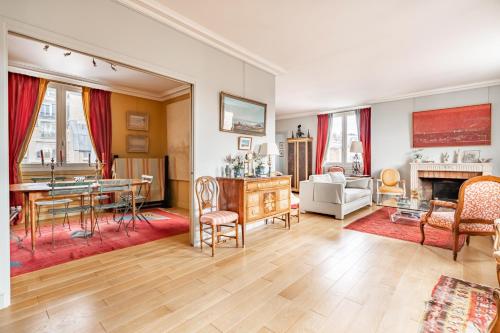 un grand salon avec une table et des chaises dans l'établissement Veeve - A Romance in Rouge, à Paris