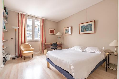 une chambre avec un lit, un bureau et une chaise dans l'établissement Veeve - A Romance in Rouge, à Paris