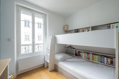 une chambre avec un lit superposé et une fenêtre dans l'établissement Veeve - A Kiss of Blue, à Paris