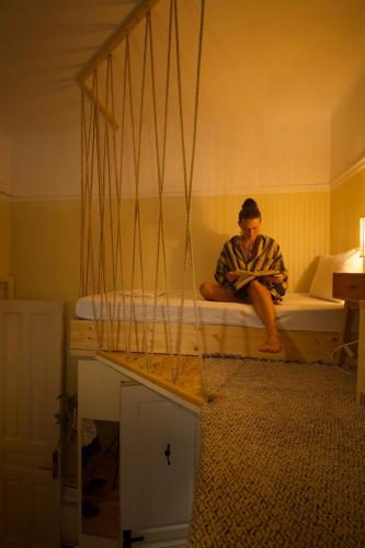 a man sitting on a bed in a room at Baloo Hostel in Athens