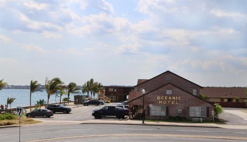 a building on a street with cars parked in a parking lot at Oceanic Motel in Ocean City