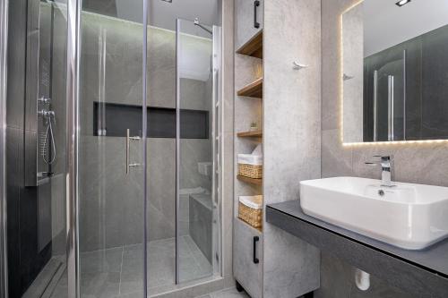 a bathroom with a sink and a glass shower at ALEXANDRA'S COMFORT CITY APARTMENT in Alexandroupoli