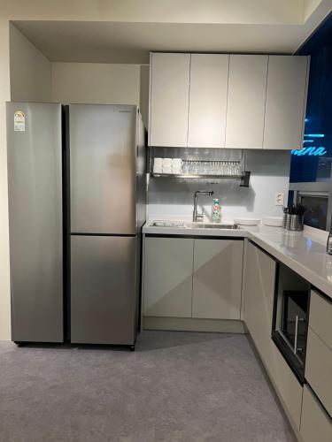 a kitchen with white cabinets and a stainless steel refrigerator at Seoul Cube Jongro in Seoul