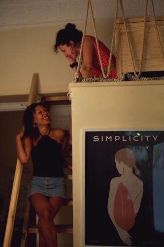 a woman standing on a ladder in a room at Baloo Hostel in Athens