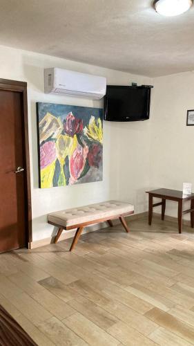 a bench in a room with a painting on the wall at Mansion Serrano Hotel in El Fuerte