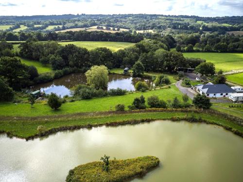 an aerial view of two lakes in a field at Peaceful ensuite lakeside cabin 'Tench' in Hadlow Down