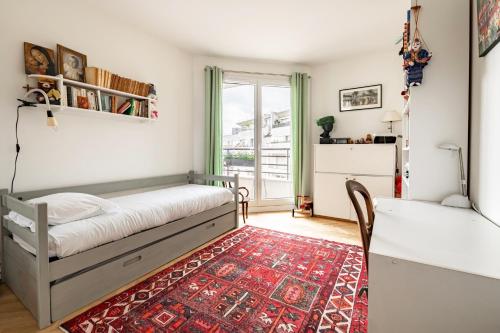 - une chambre avec un lit, une table et un tapis dans l'établissement Veeve - From Levallois With Love, à Levallois-Perret