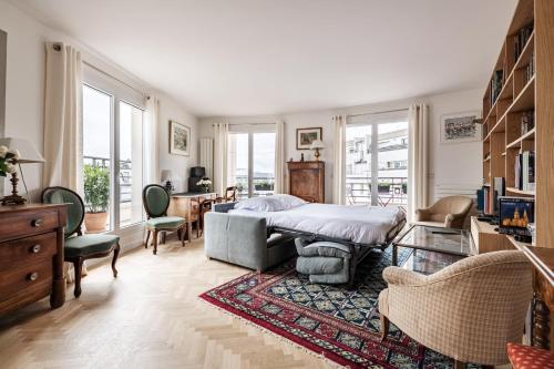 une chambre avec un lit, une table et des chaises dans l'établissement Veeve - From Levallois With Love, à Levallois-Perret