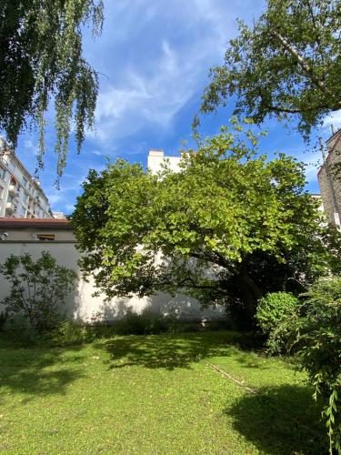 un arbre au milieu d'une cour dans l'établissement Studio calme et lumineux, parking disponible, 100m de Nation, à Paris