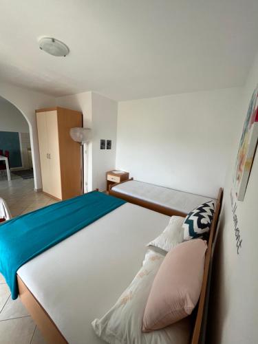 a bedroom with a large bed with blue sheets and pillows at Apartments Edina in Pag