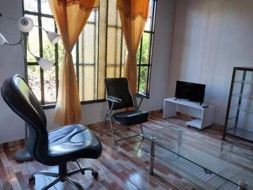 a living room with two chairs and a glass table at CASA PROYECTO GIGANTE in Gigante