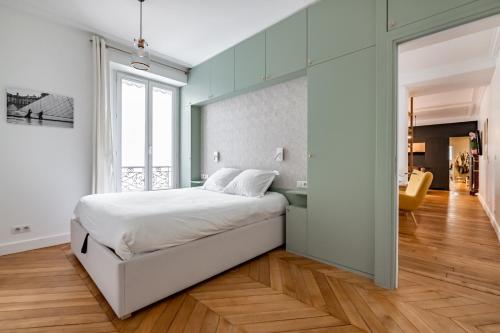 a bedroom with a white bed and a glass wall at Veeve - Back to Black in Paris