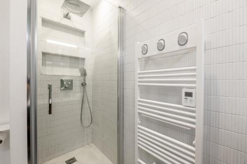 a shower with a glass door in a bathroom at Veeve - Back to Black in Paris