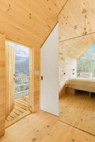 a wooden room with a bed and a large window at Suite Etoile in Villa dʼAllegno