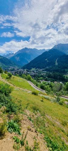 um campo com uma estrada e montanhas à distância em Suite Etoile em Villa dʼAllegno