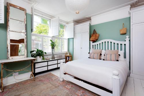 a bedroom with a white bed and blue walls at Veeve - True Romance in London
